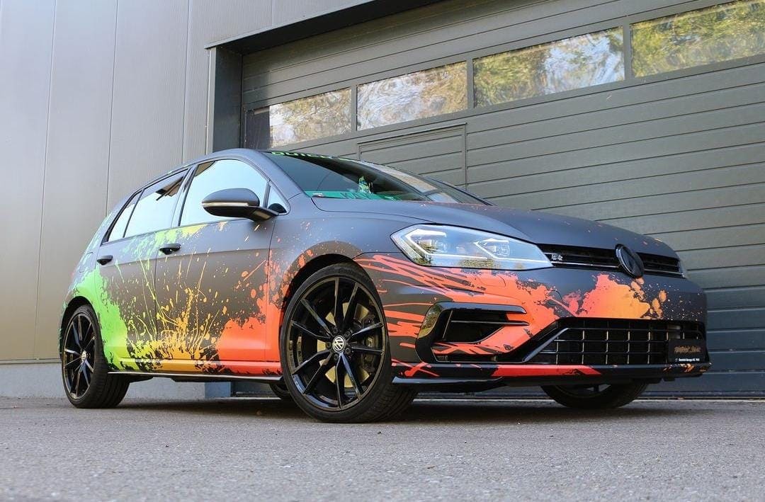 Seitliche Detailansicht eines Sportwagens mit orangenem FlammendesignHintergrund.