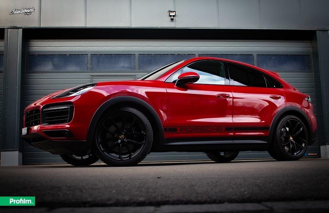 Rotes Auto mit schwarzen Felgen und Spiegelungen.