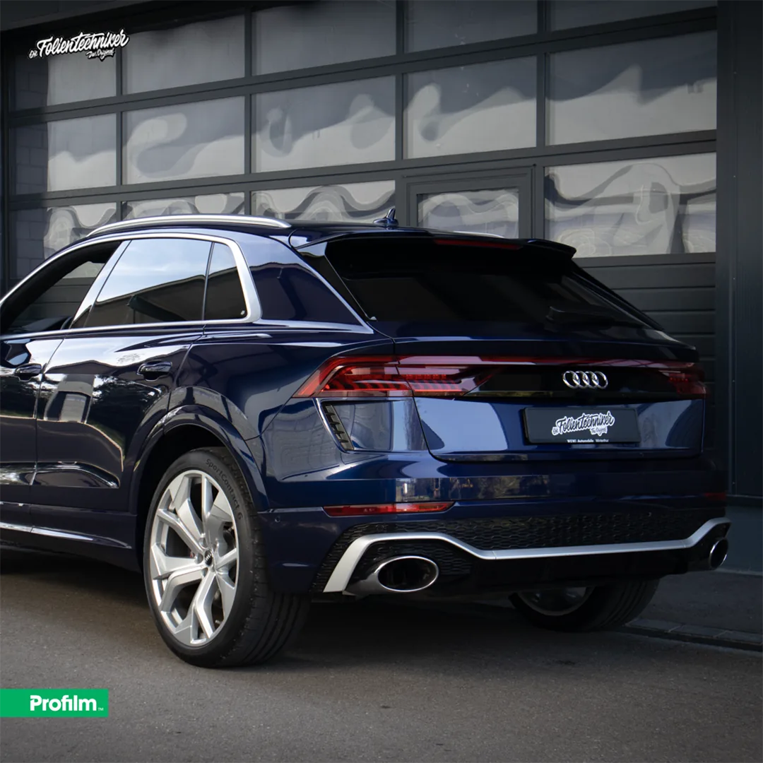 Dunkelblauer Audi RS Q8 mit getönten Scheiben, Heckansicht vor einem Garagentor